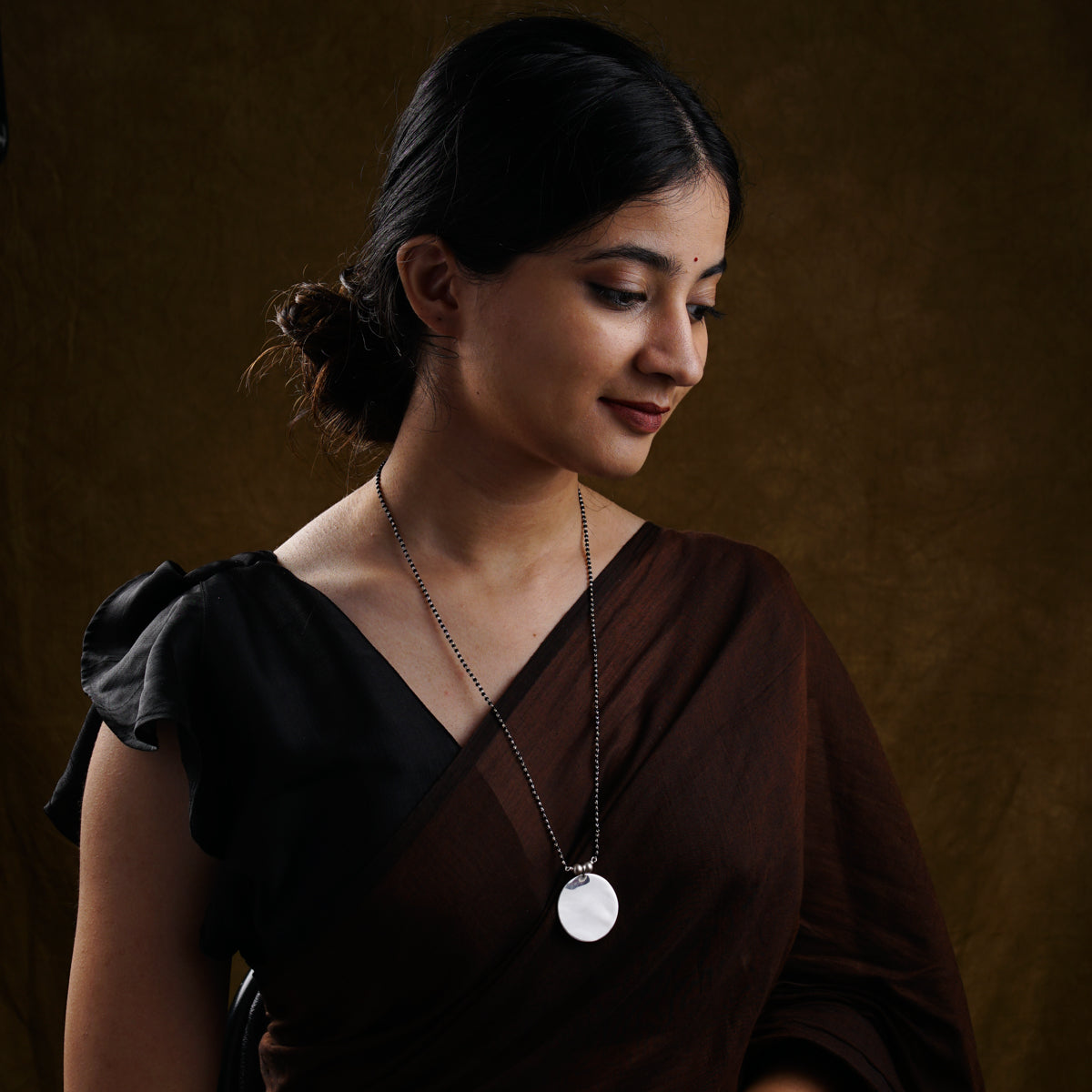 a woman in a brown dress holding a cell phone