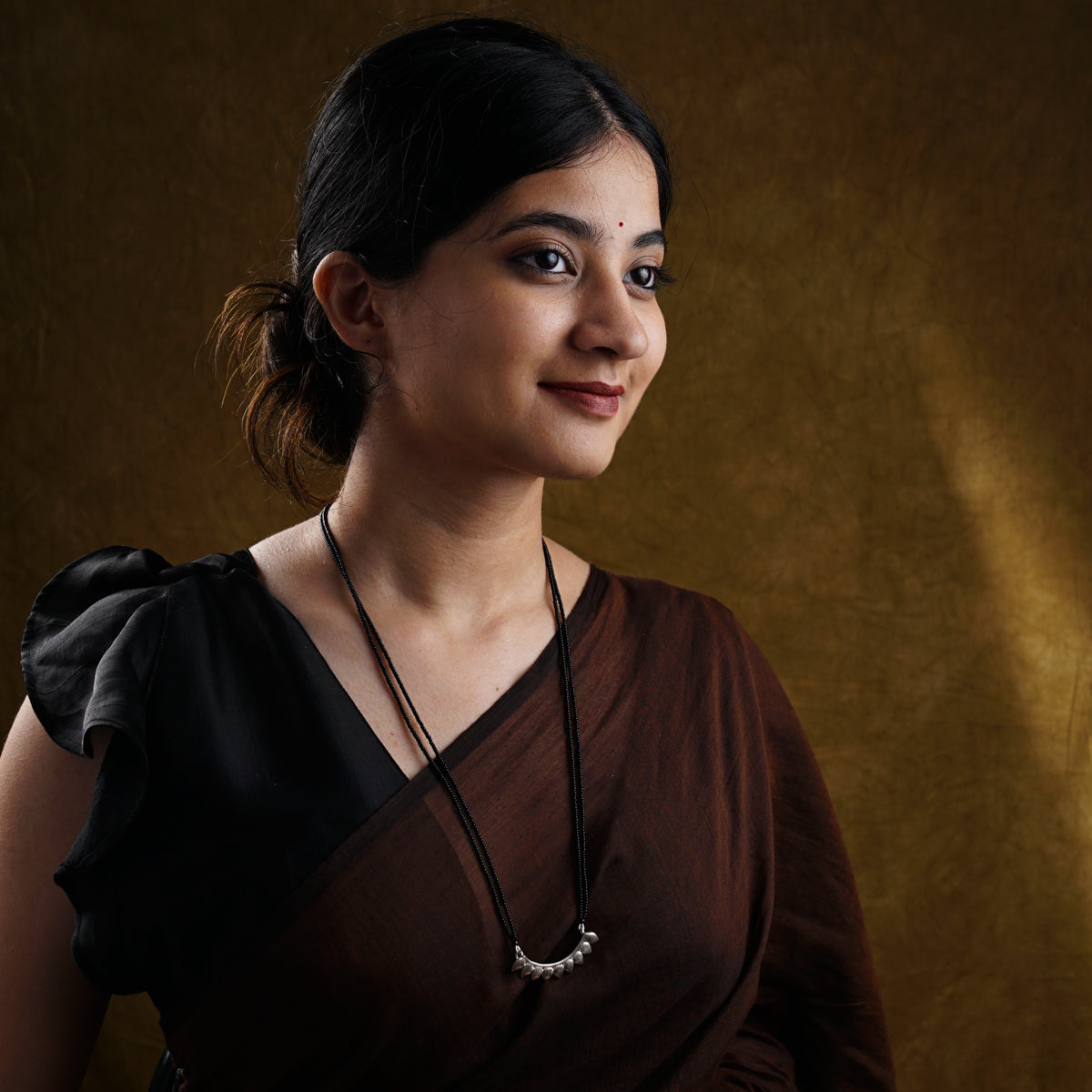 a woman in a brown dress posing for a picture