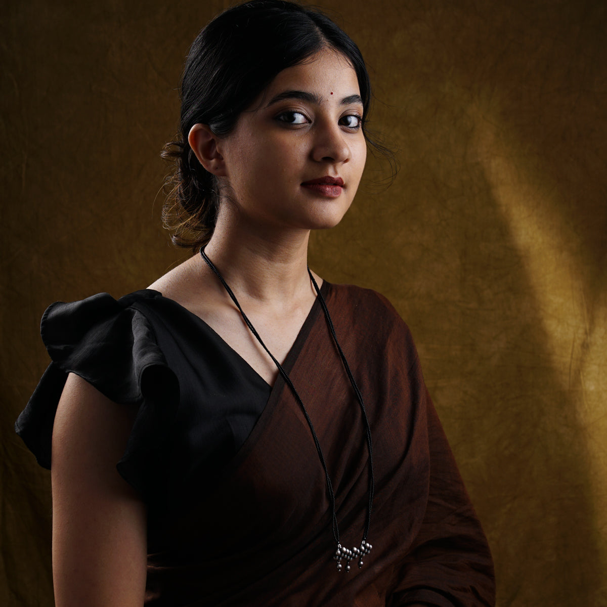 a woman in a brown dress posing for a picture