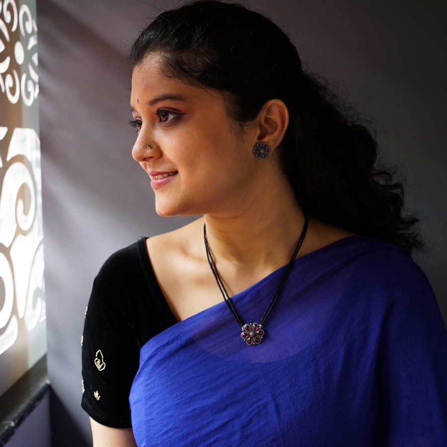 a woman in a blue sari looking out a window