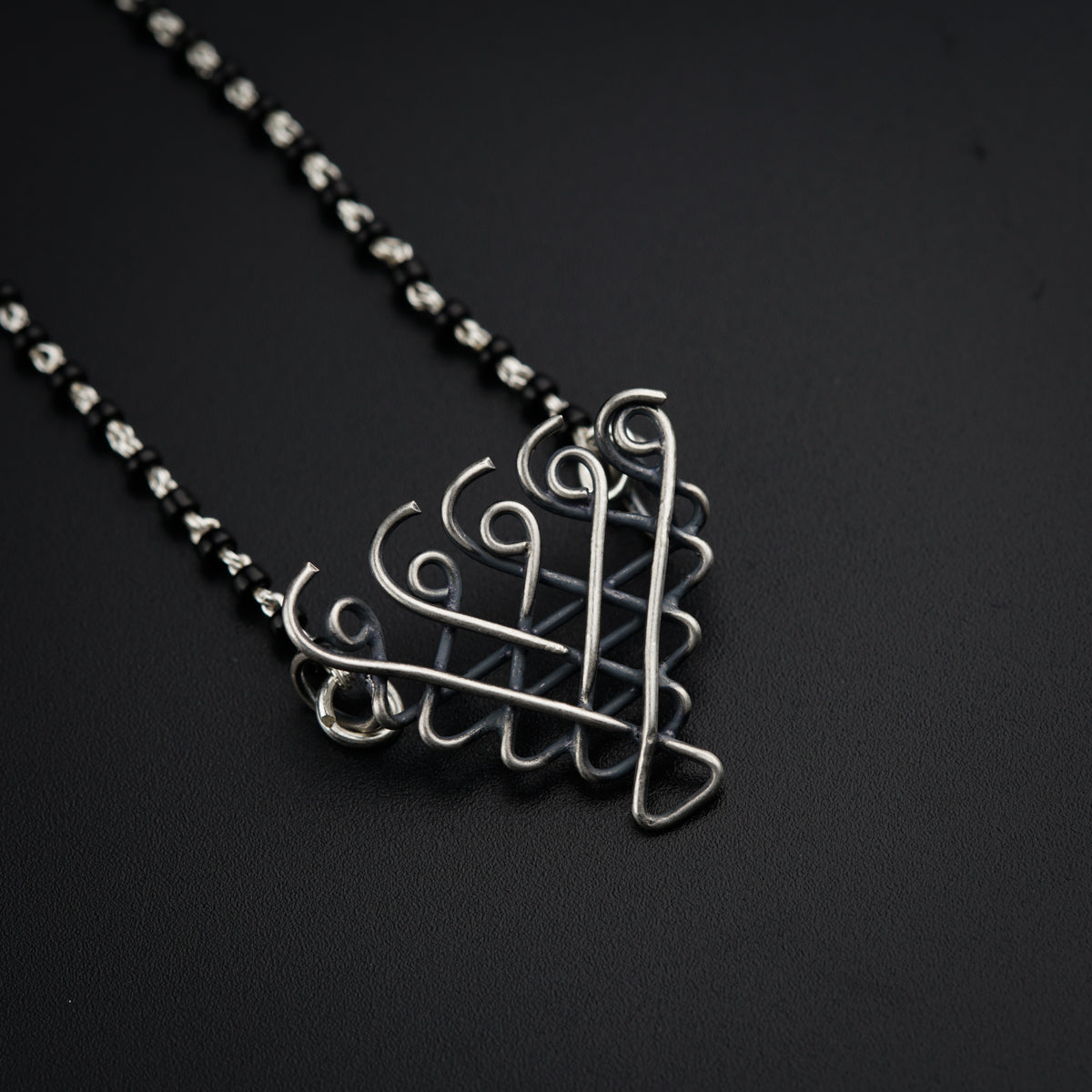a silver necklace with a design on it