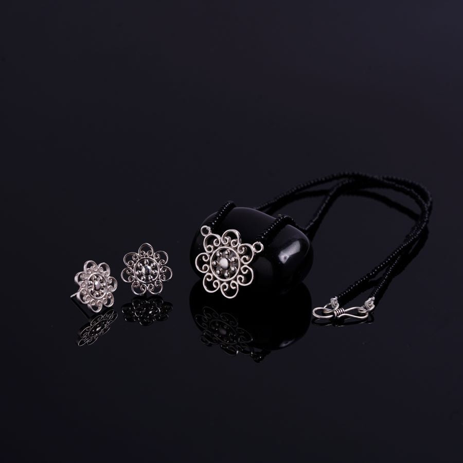 three pieces of jewelry on a black surface