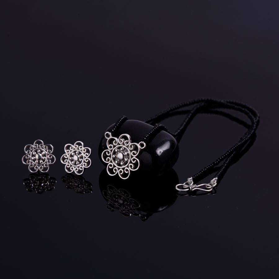 three pieces of jewelry on a black surface