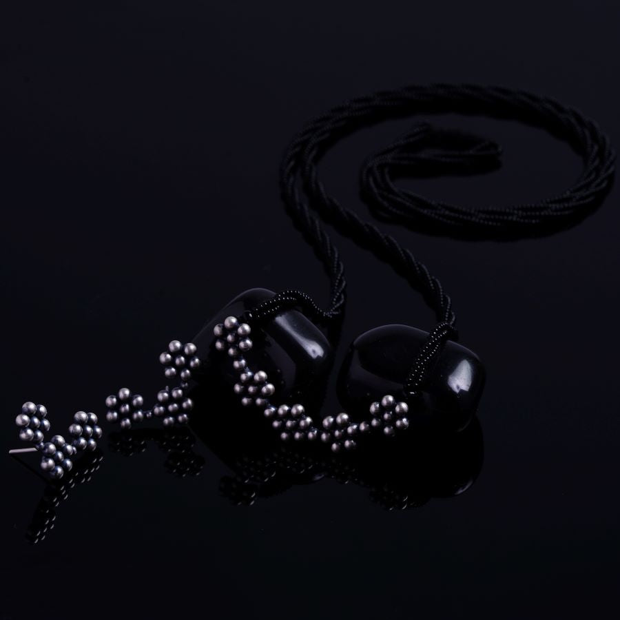 a pair of ear buds with pearls on a black background