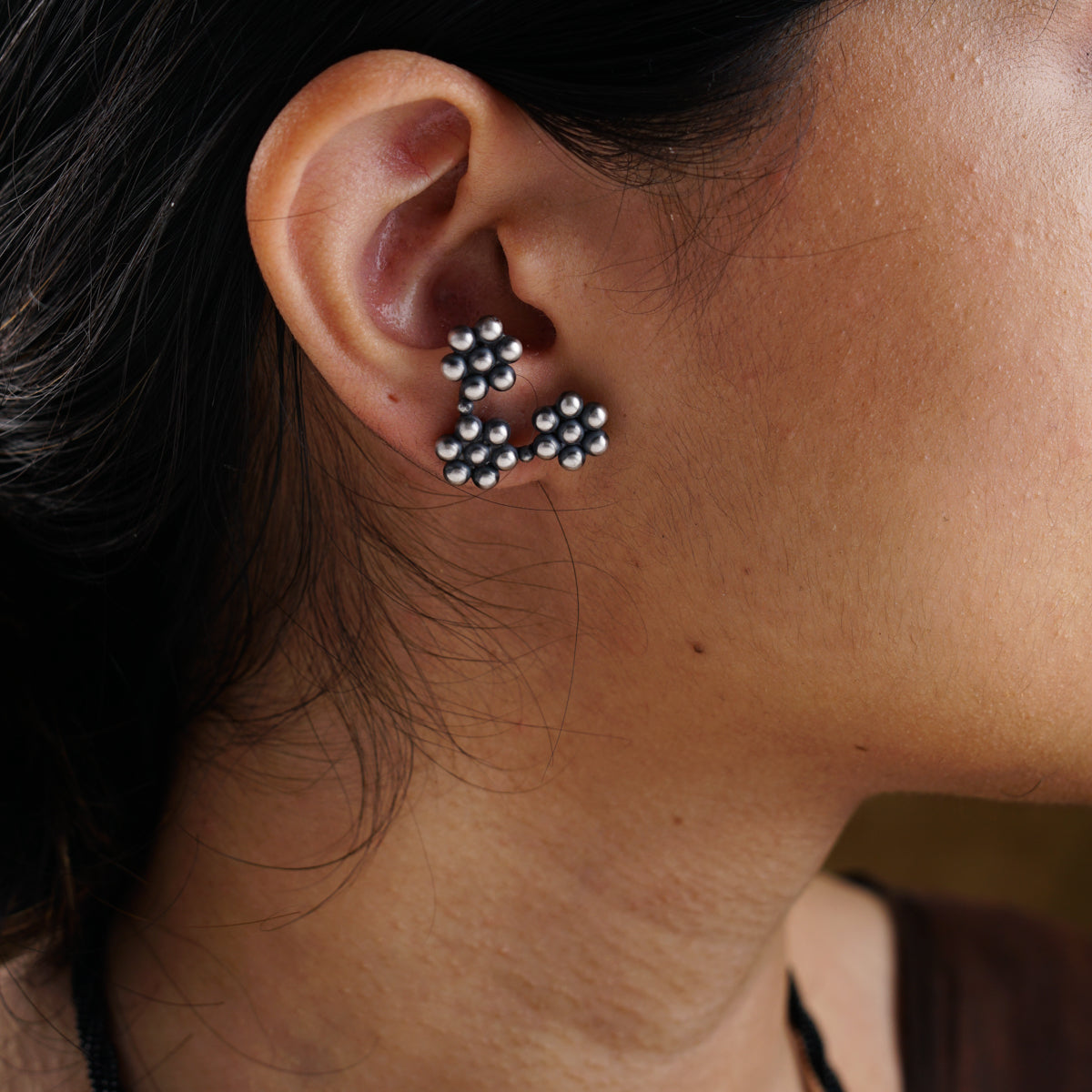 a close up of a person wearing a pair of earrings