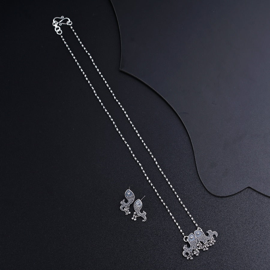 a necklace and earrings on a black surface