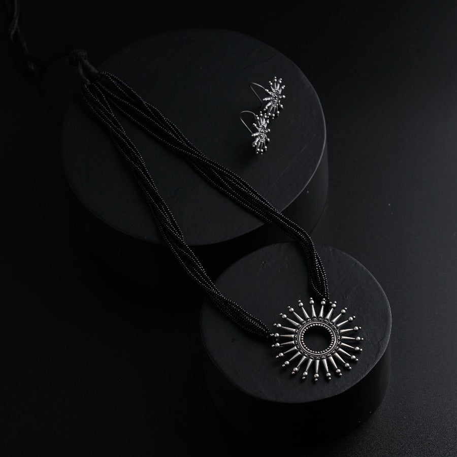 a pair of necklaces sitting on top of a black surface