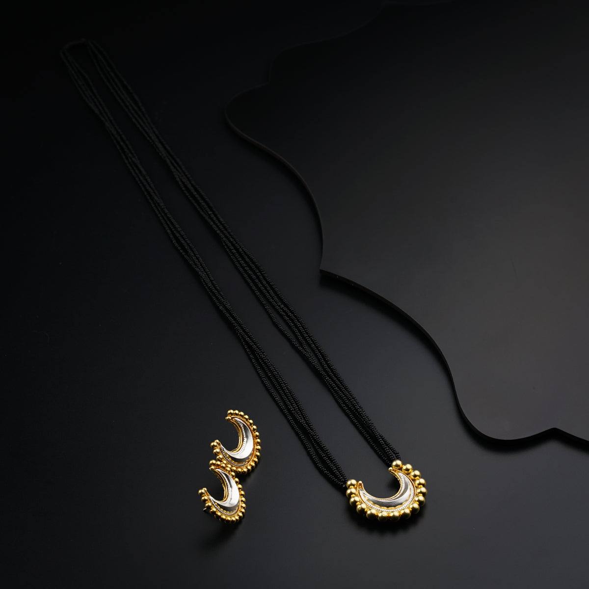 a pair of necklaces sitting on top of a black table