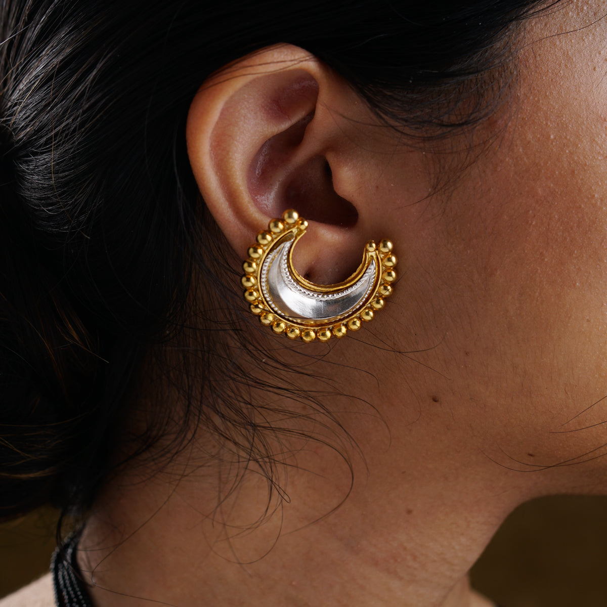 a close up of a person wearing a pair of earrings