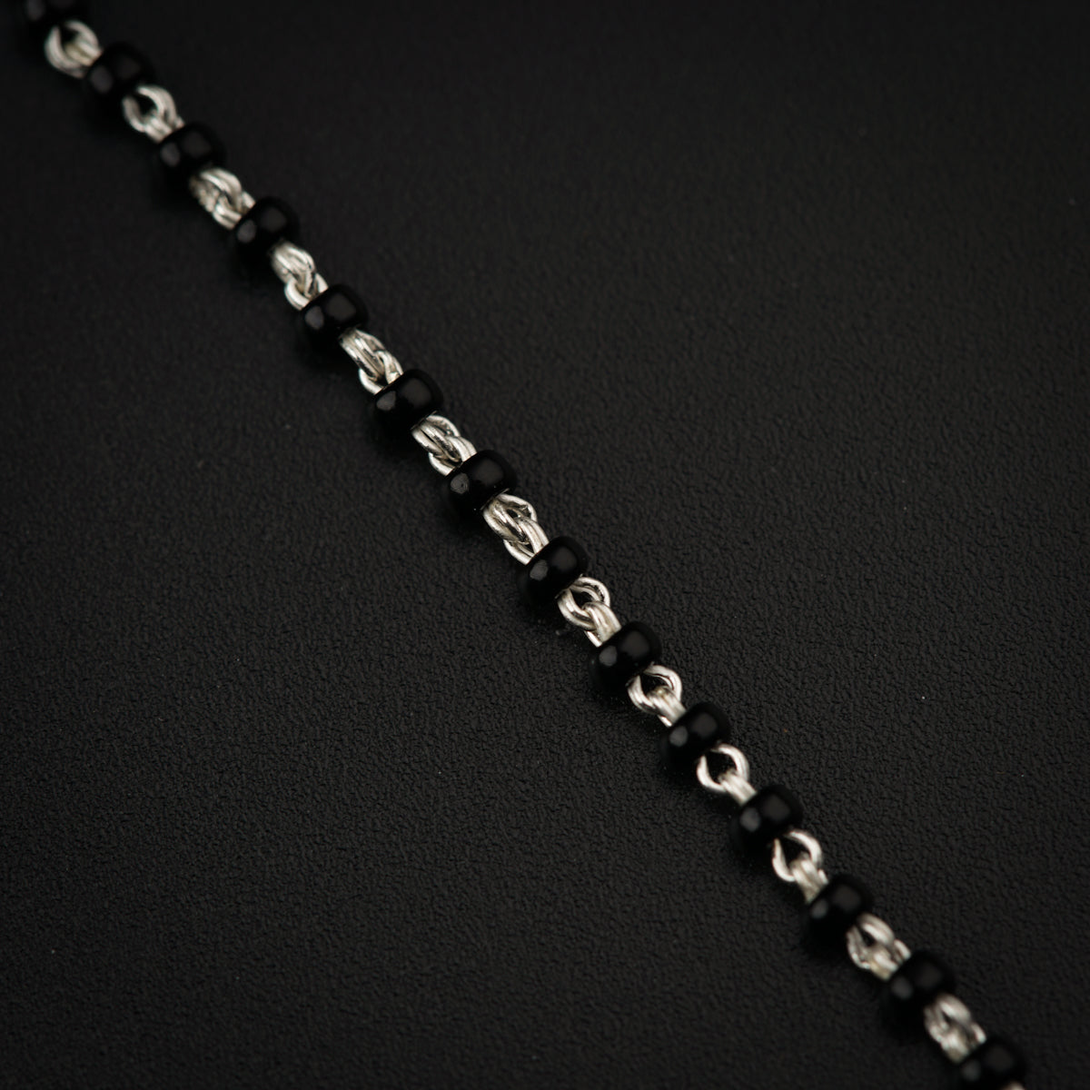 a close up of a chain on a black surface
