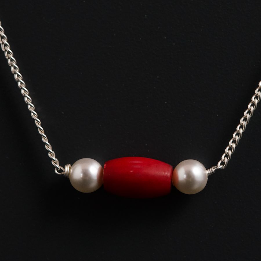 a red and white beaded necklace on a chain