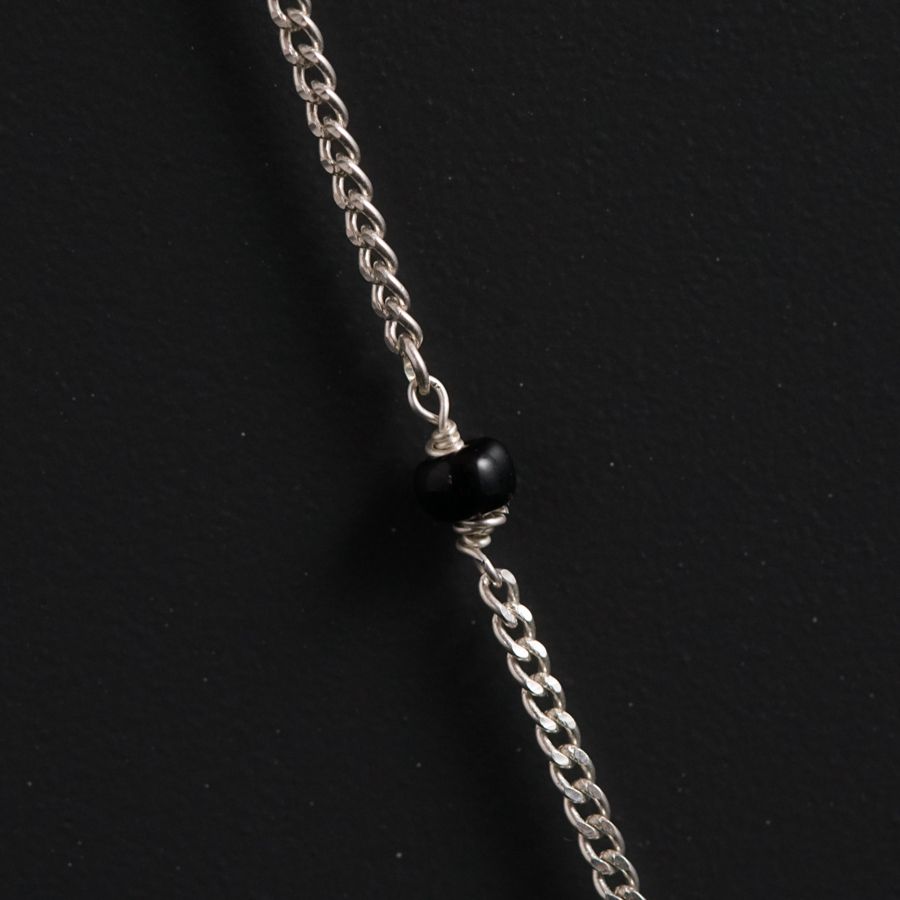 a chain with a black bead hanging from it