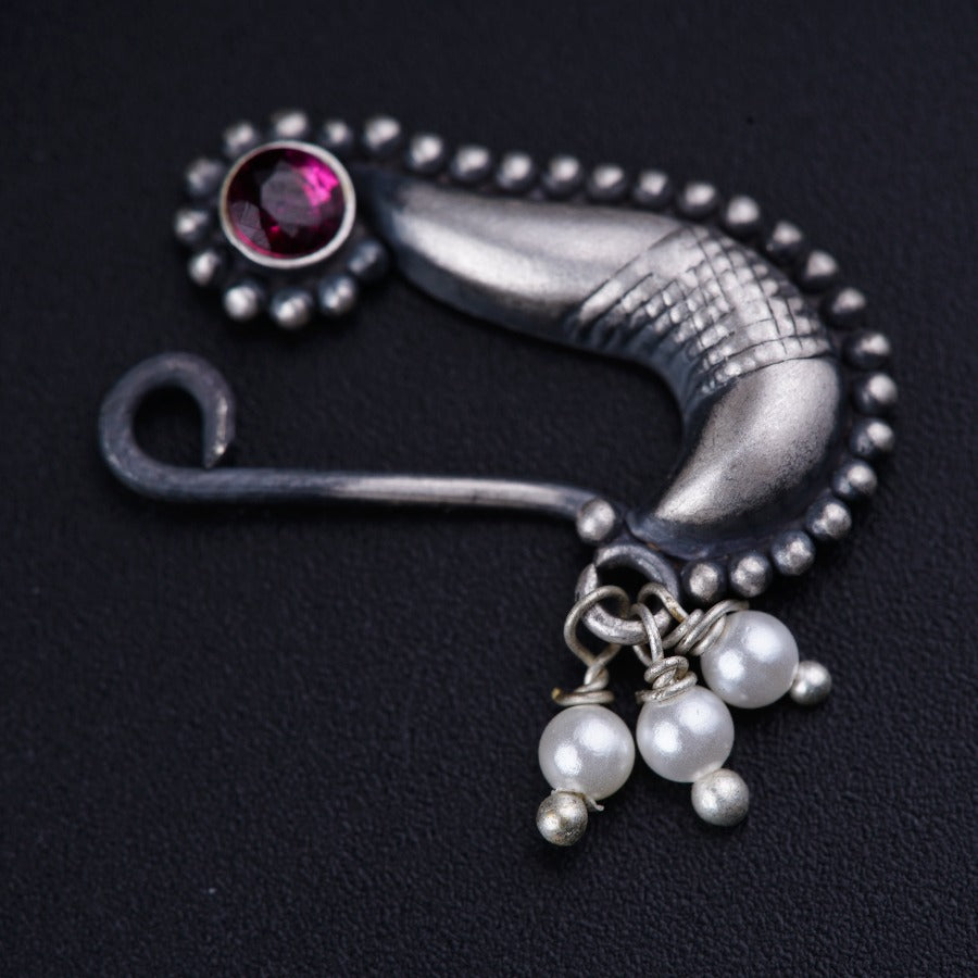 a close up of a brooch with pearls