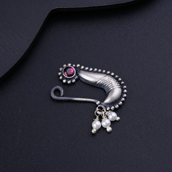 a close up of a brooch with pearls