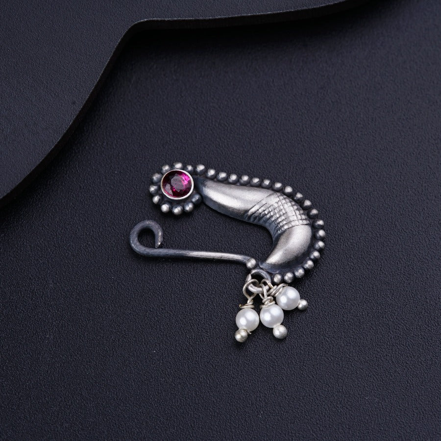 a close up of a brooch with pearls