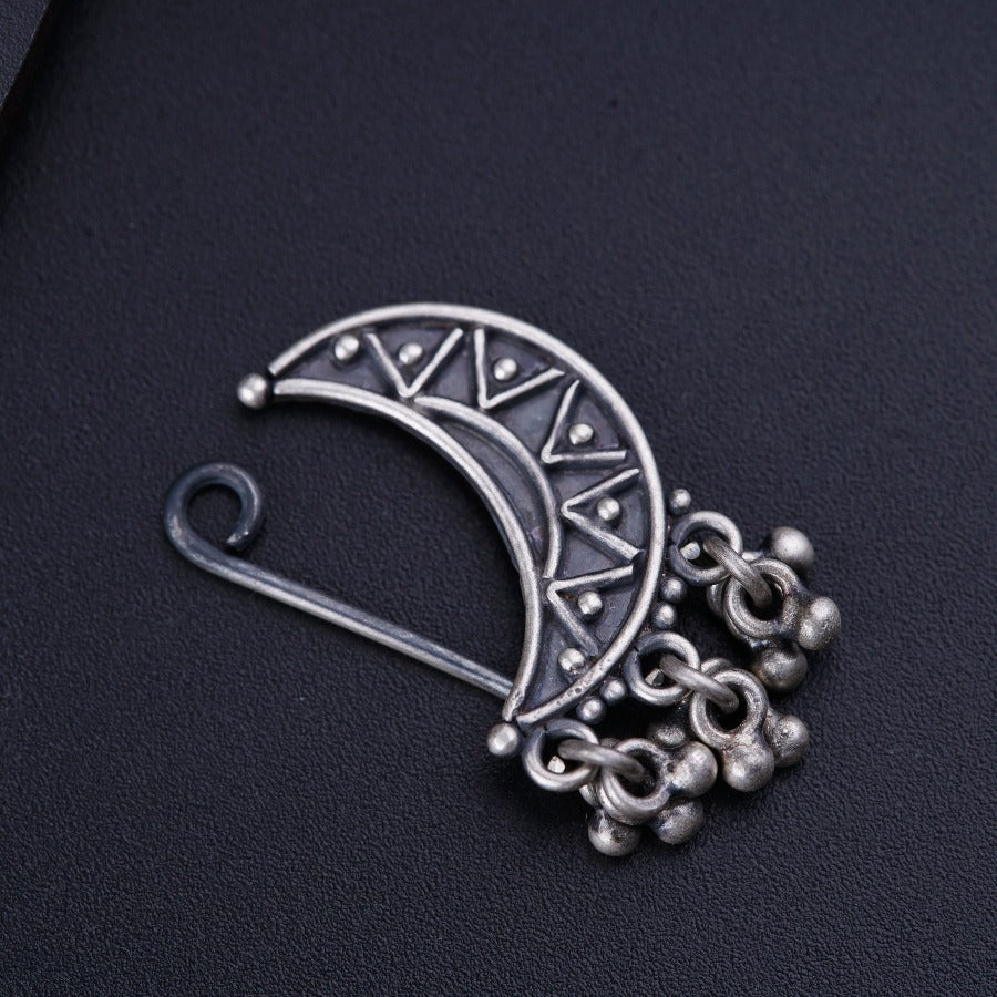 a silver brooch with a crescent design on it