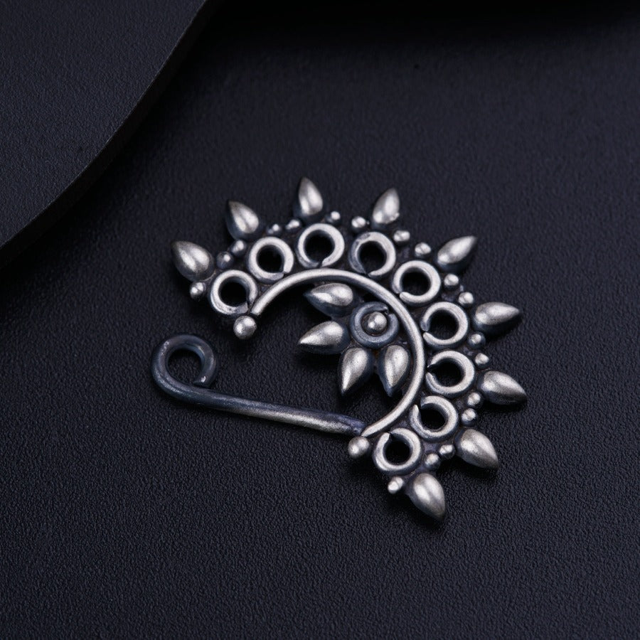 a close up of a brooch on a black surface