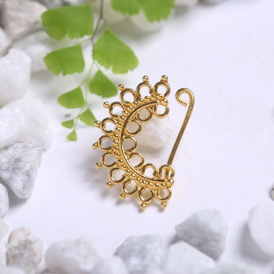 a gold brooch sitting on top of a pile of rocks