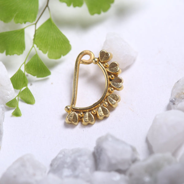 a gold nose ring sitting on top of a pile of rocks