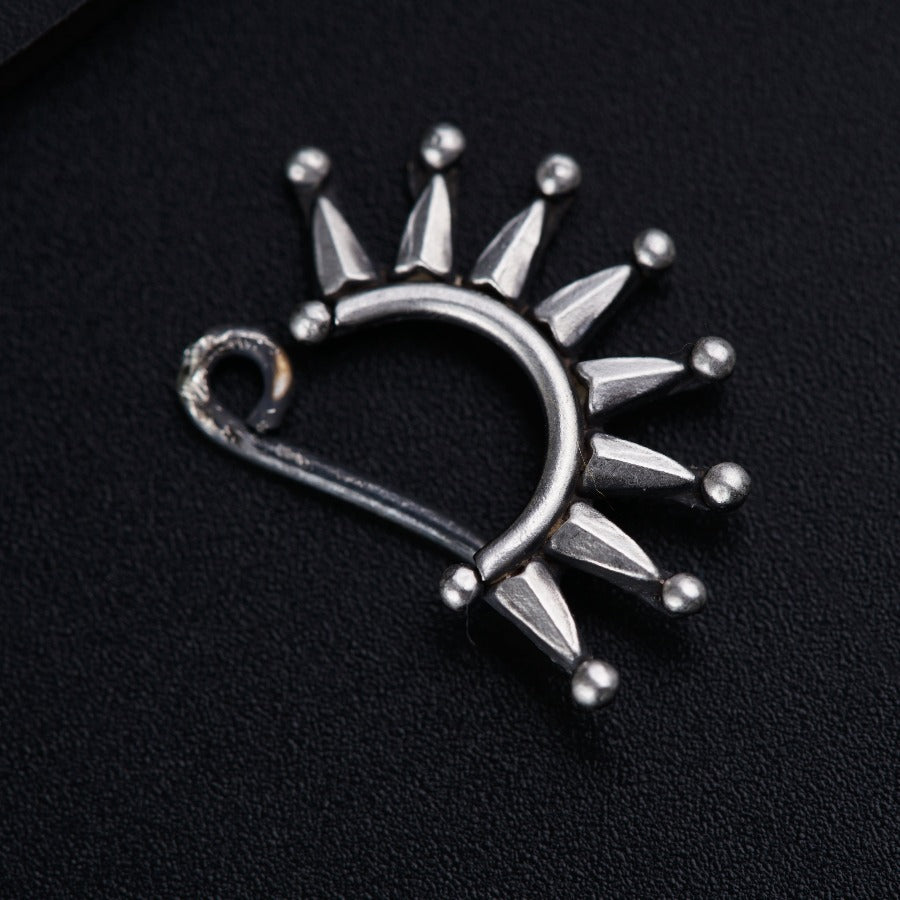 a silver brooch with spikes on it