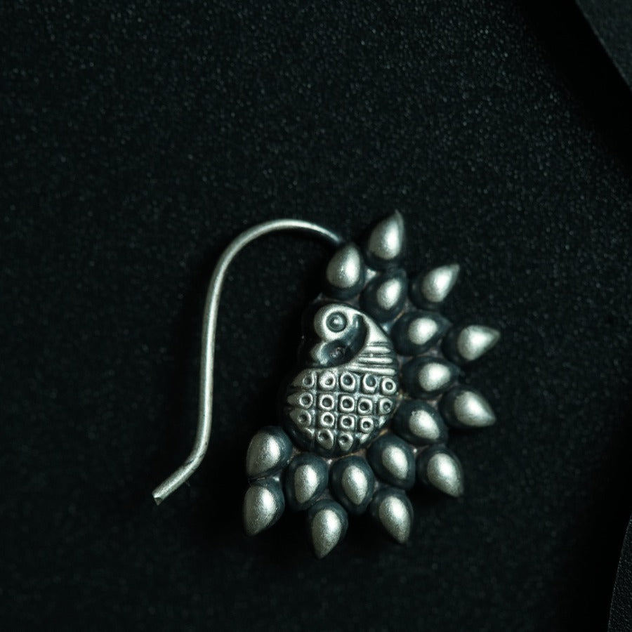 a close up of a brooch on a black surface