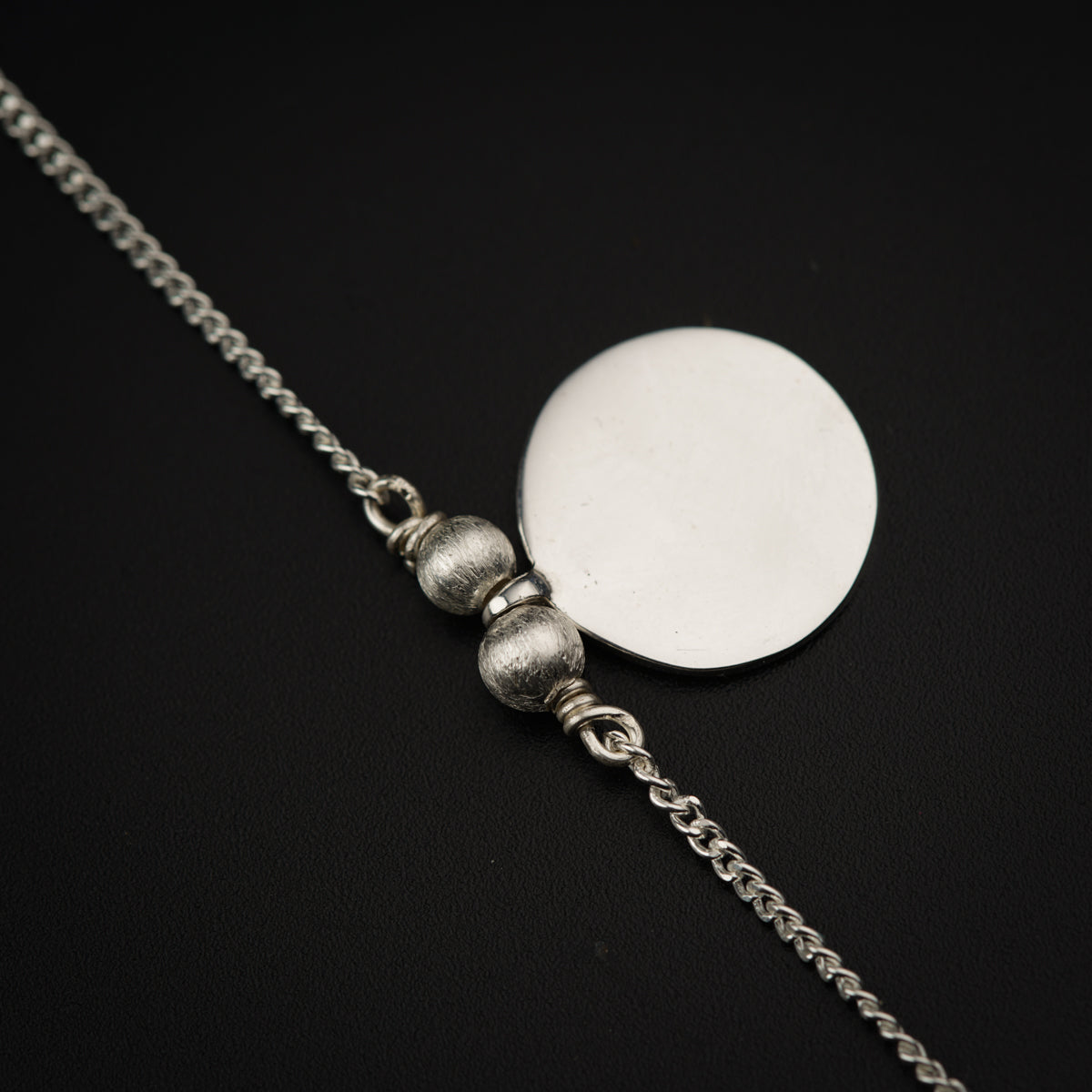 a silver necklace with two balls on it