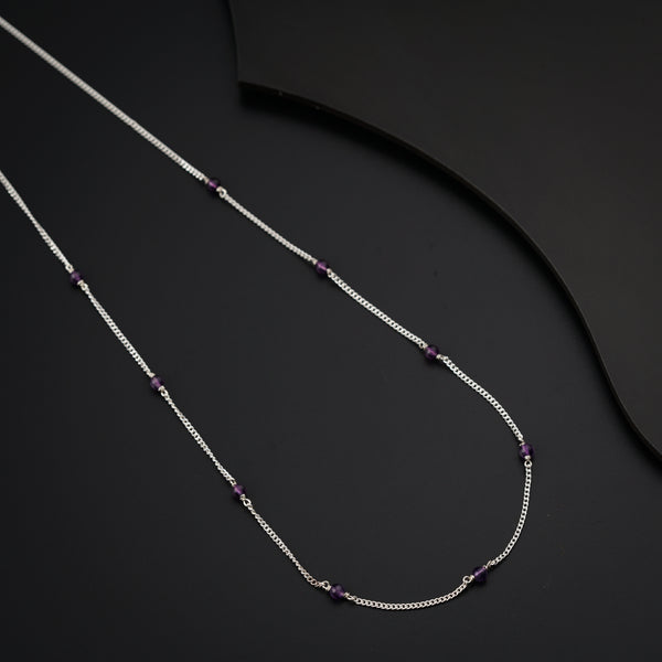 a necklace with beads and a knife on a table