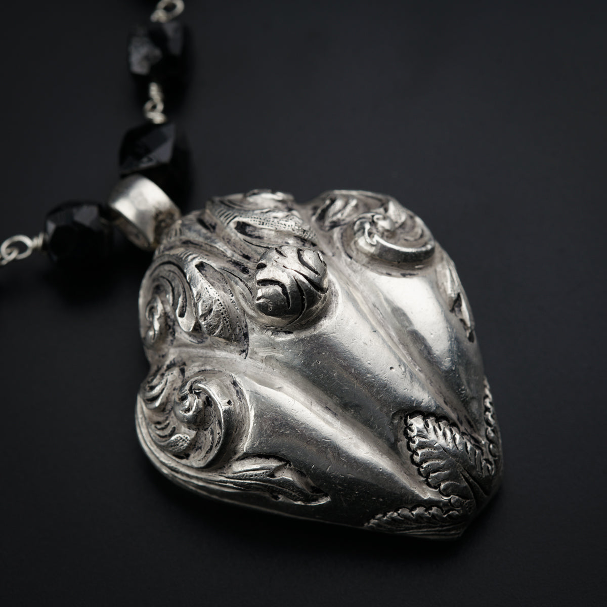 a silver necklace with a face on it
