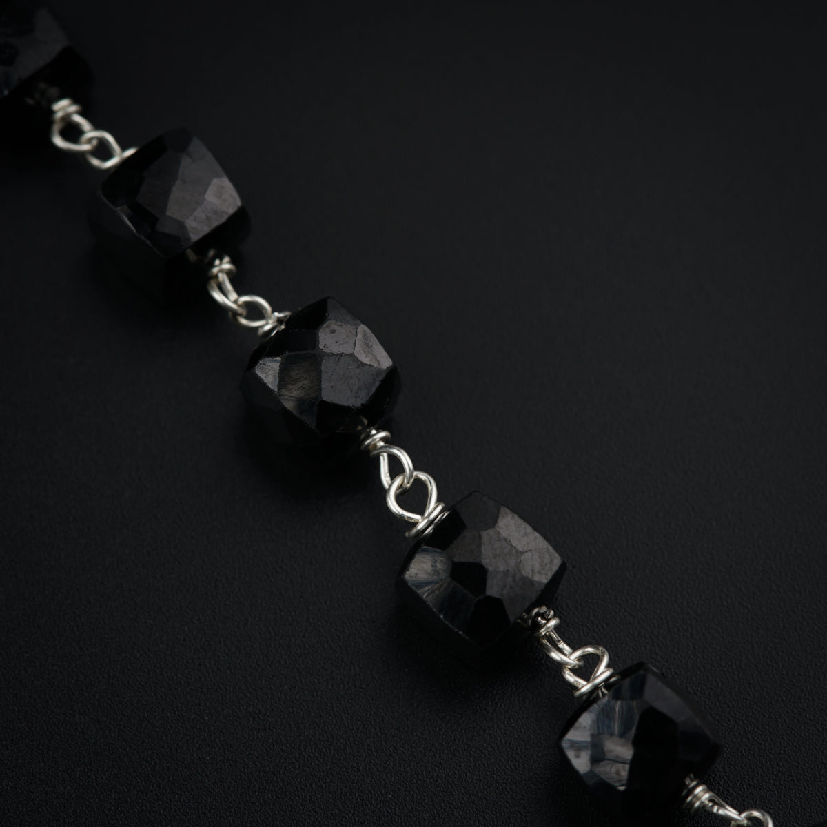 a black beaded bracelet on a black surface