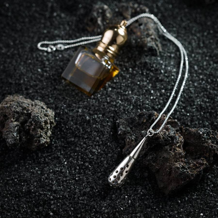 a bottle of perfume sitting on top of a rock