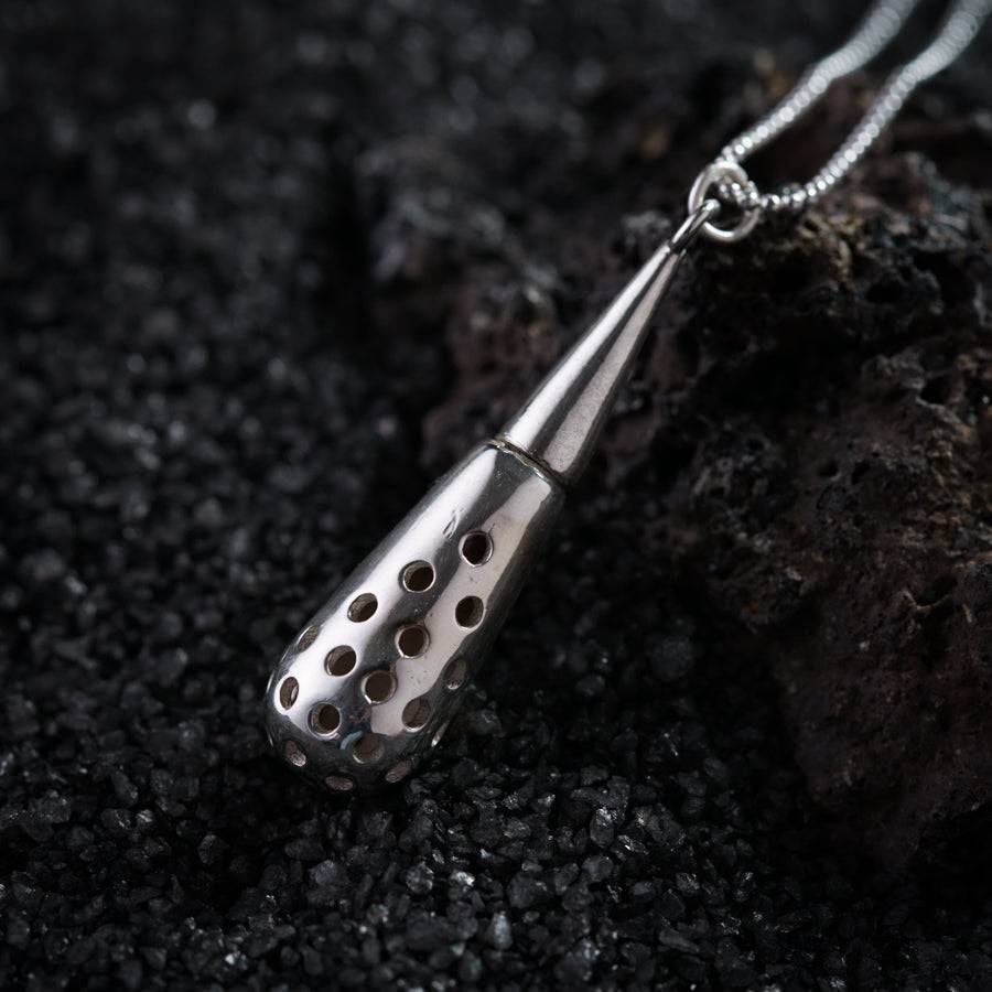 a close up of a metal object on a chain