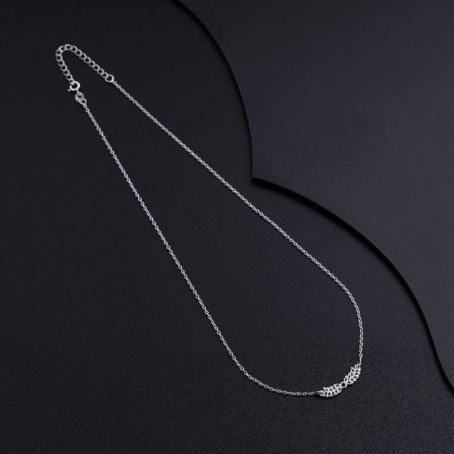a silver necklace with a chain on a black background