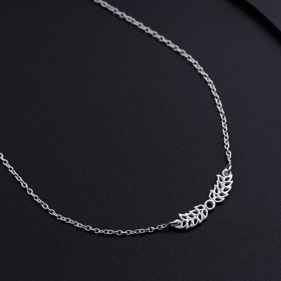 a silver chain with a leaf design on it
