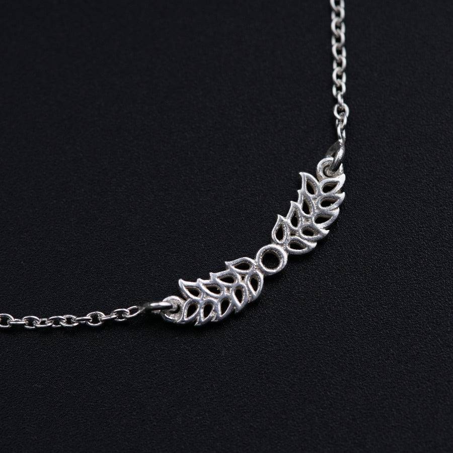 a silver necklace with leaves on it