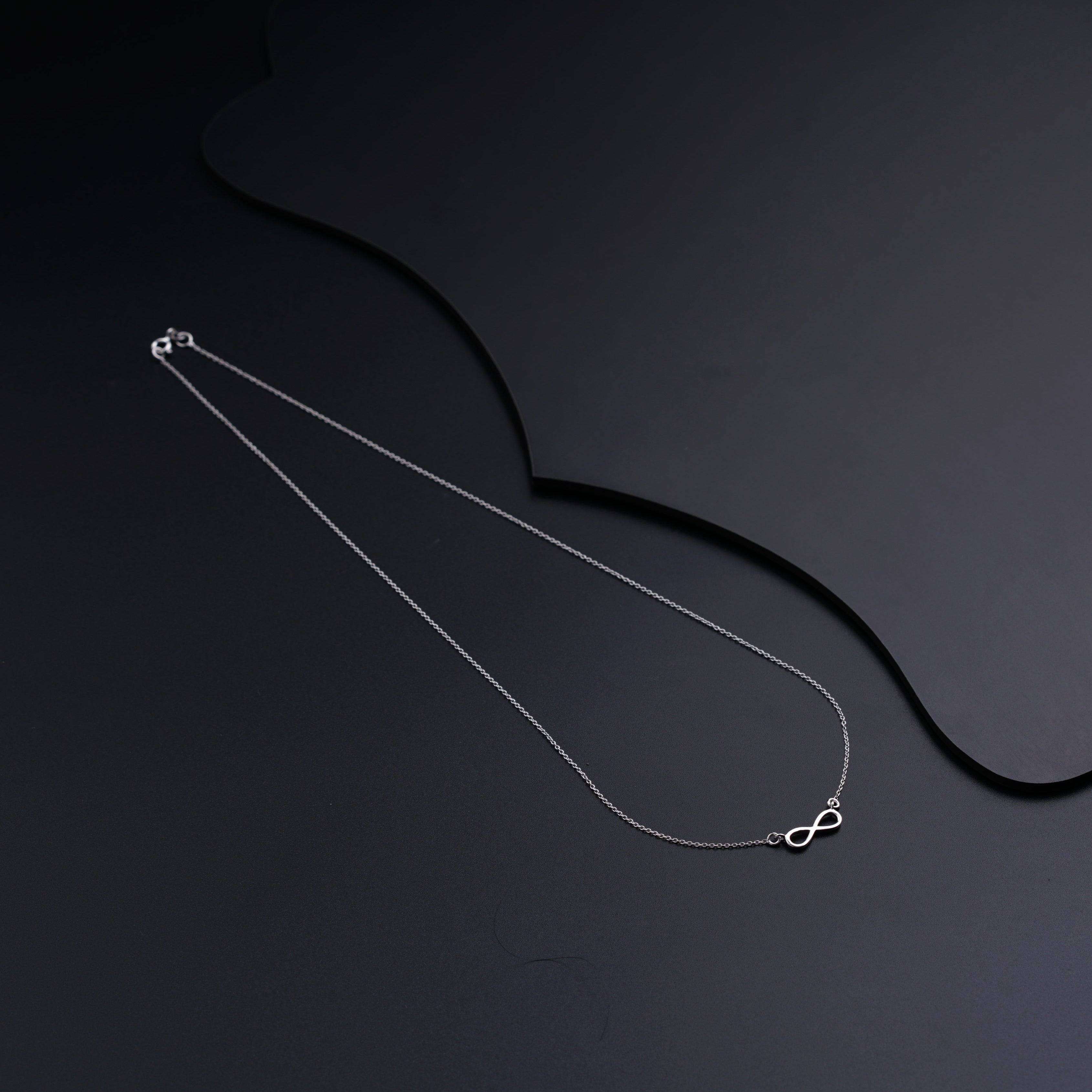 a necklace with a heart on a black background