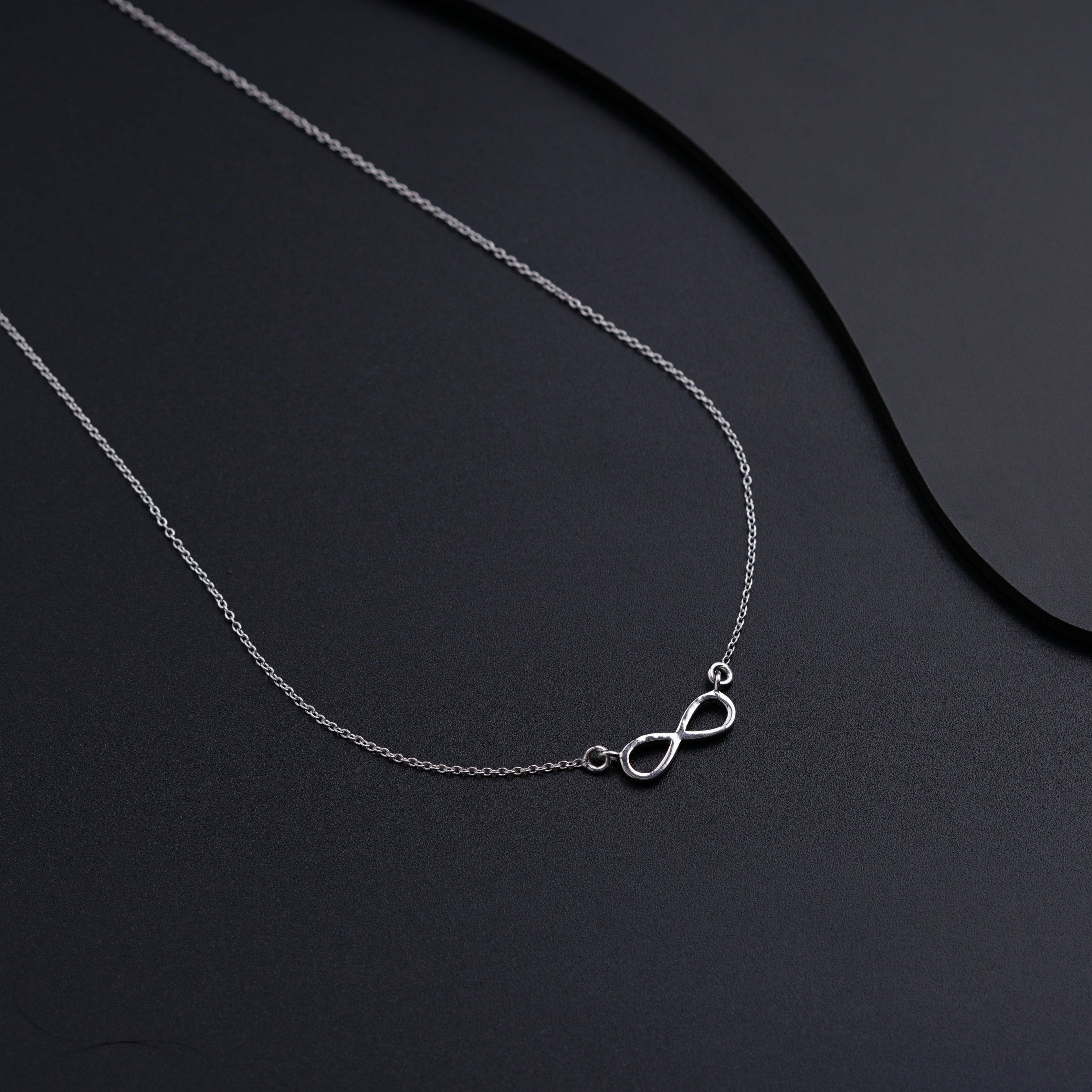 a close up of a necklace on a black surface