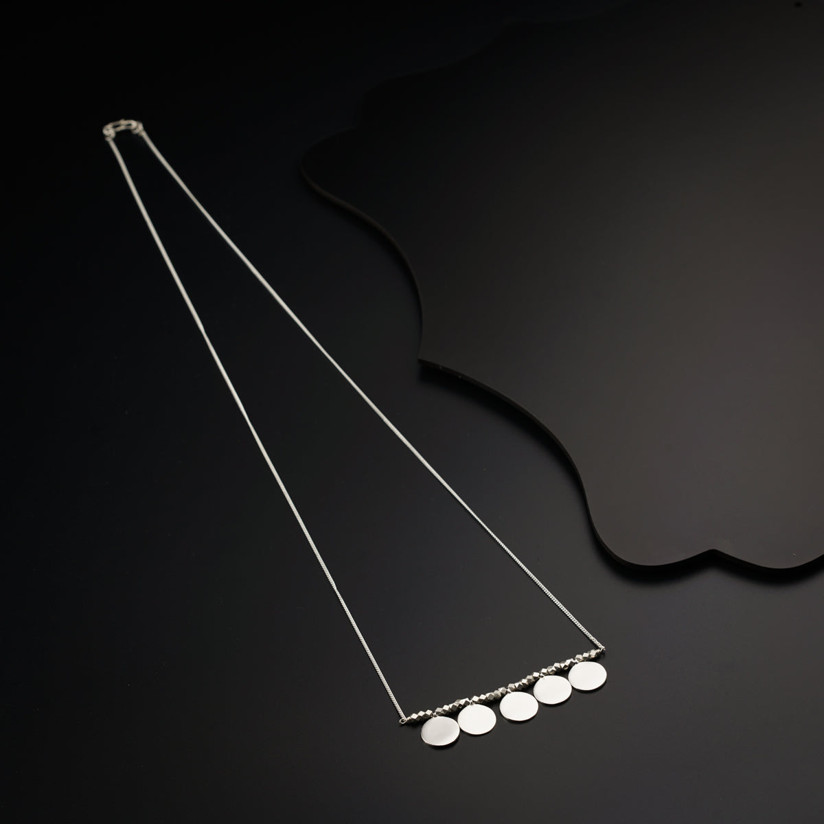 a pair of necklaces sitting on top of a table