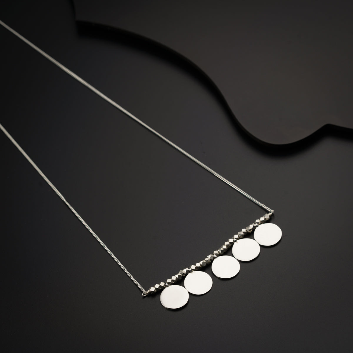 a necklace with five discs hanging from it