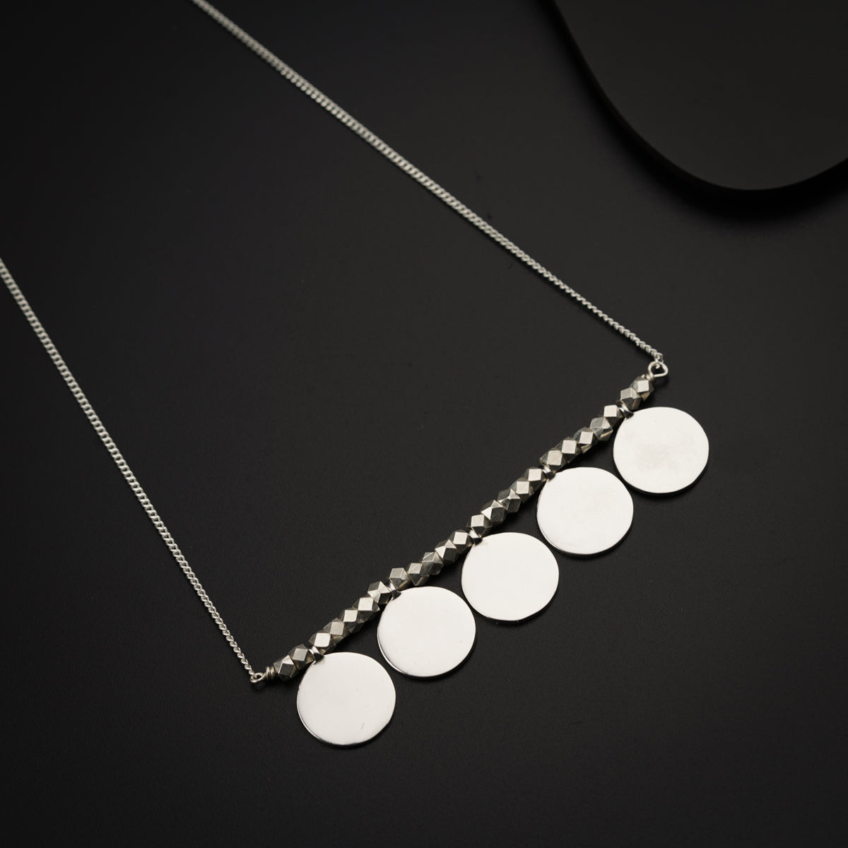 a necklace with five discs hanging from it