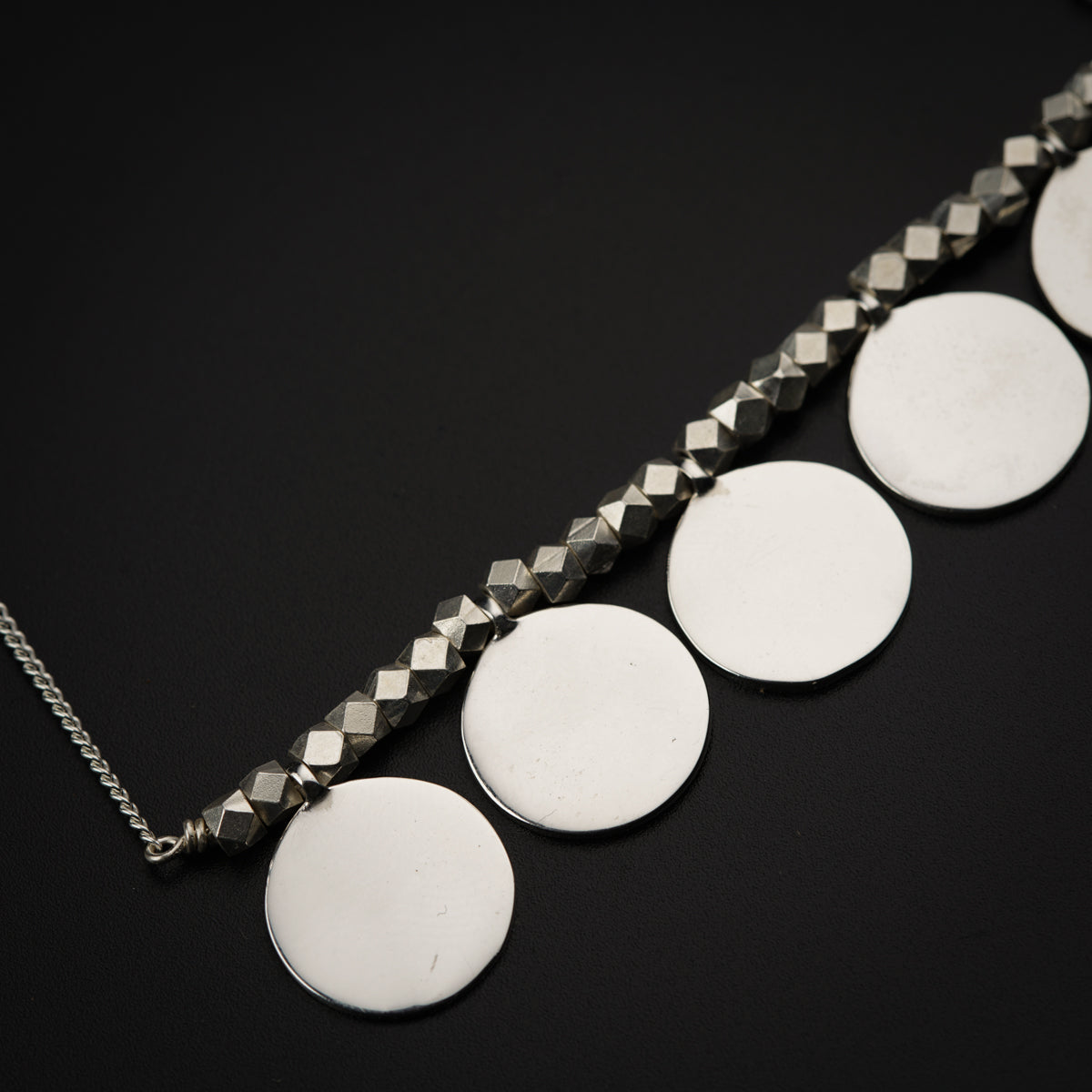 a close up of a necklace on a black surface