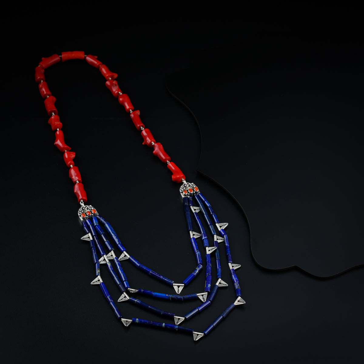 a red, white and blue necklace on a black background