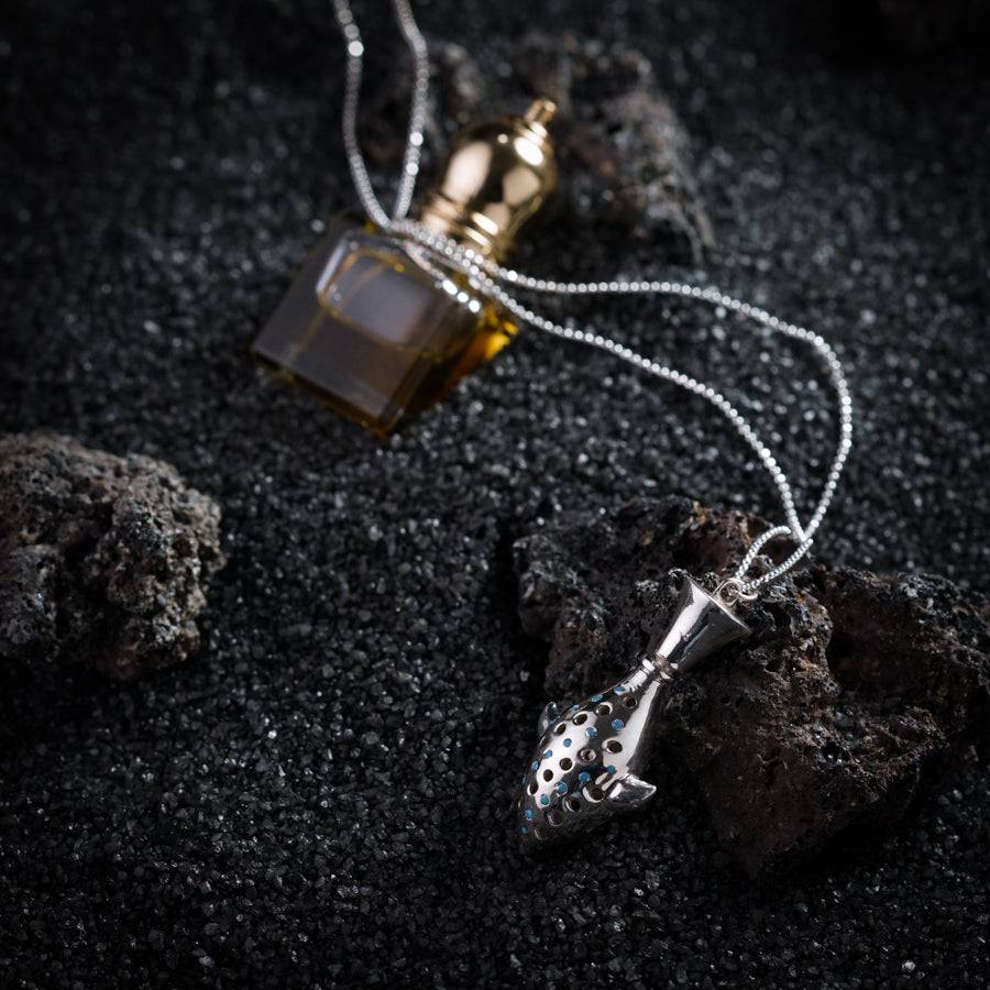 a bottle of perfume sitting on top of a rock