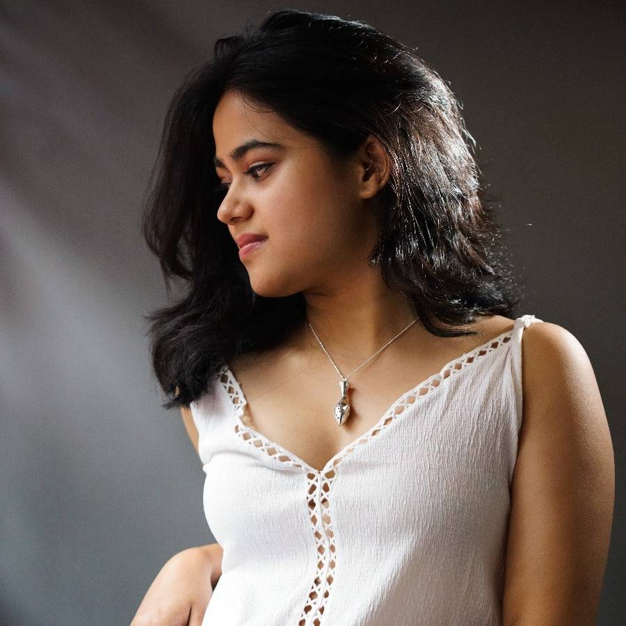 a woman in a white top holding a cell phone