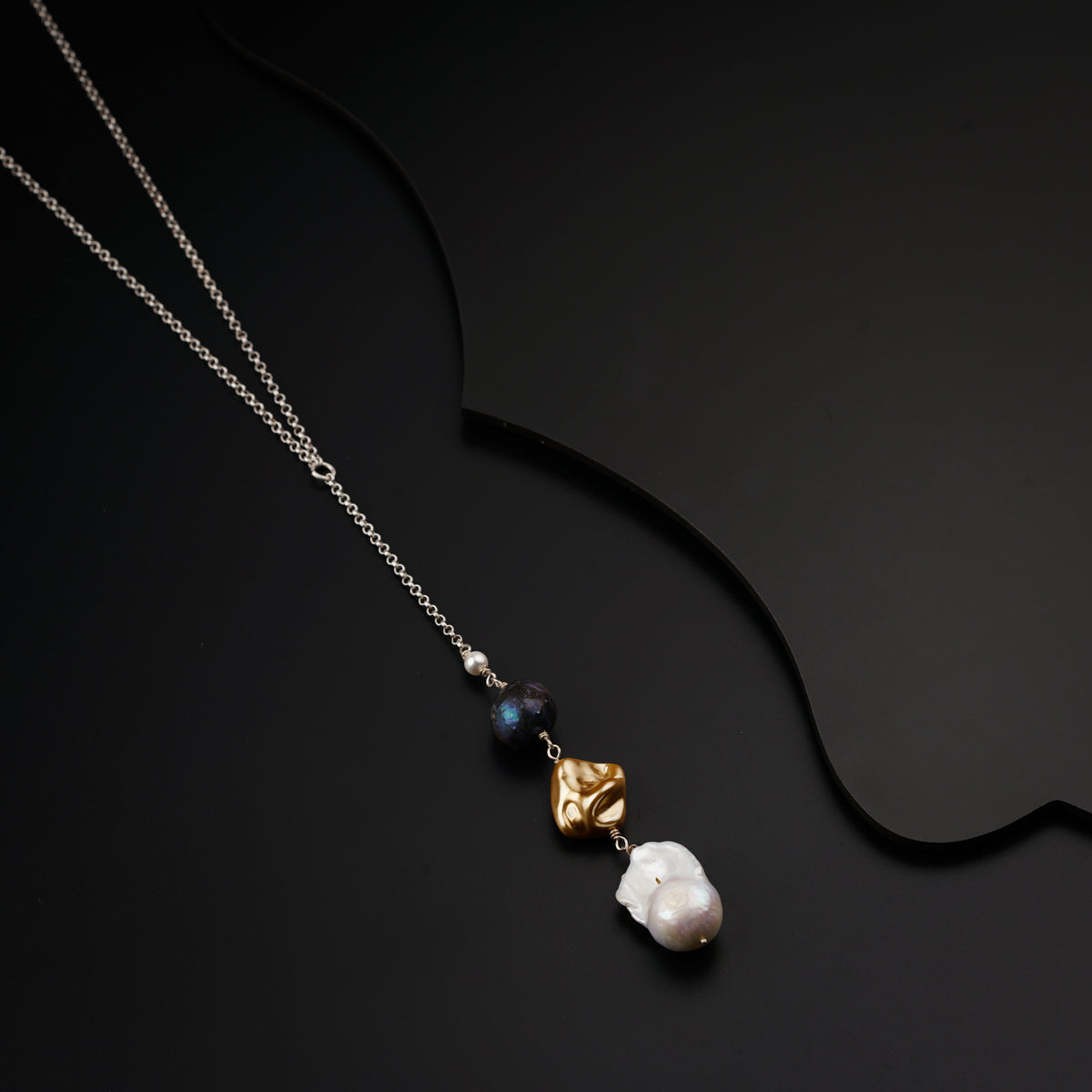 a necklace with two pearls and a heart on it