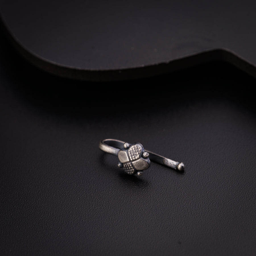 a small silver ring sitting on top of a black surface