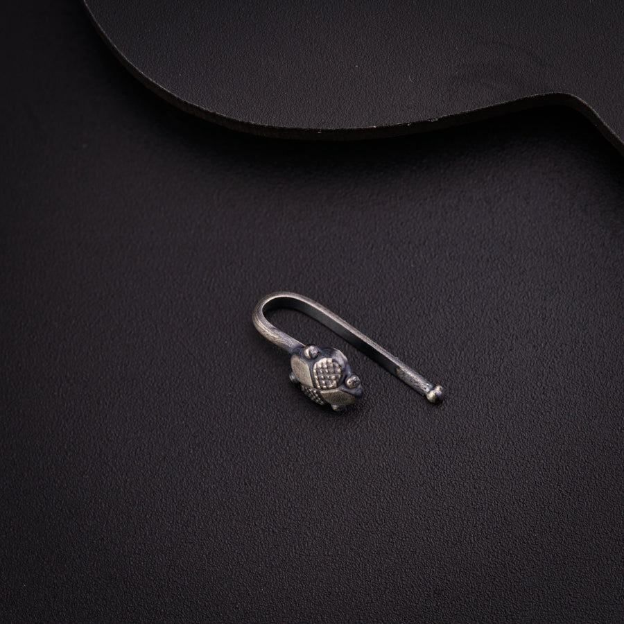 a guitar pick and a pair of scissors on a black surface