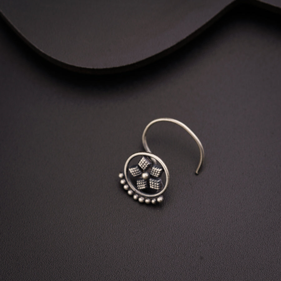 a close up of a pair of earrings on a black surface
