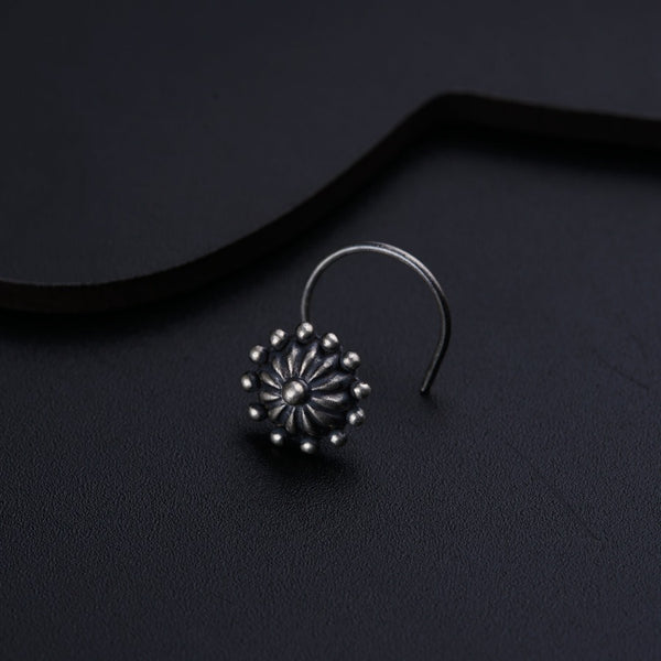 a pair of silver earrings on a black surface