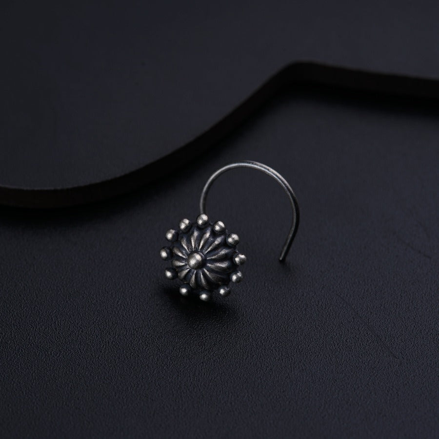 a pair of silver earrings on a black surface