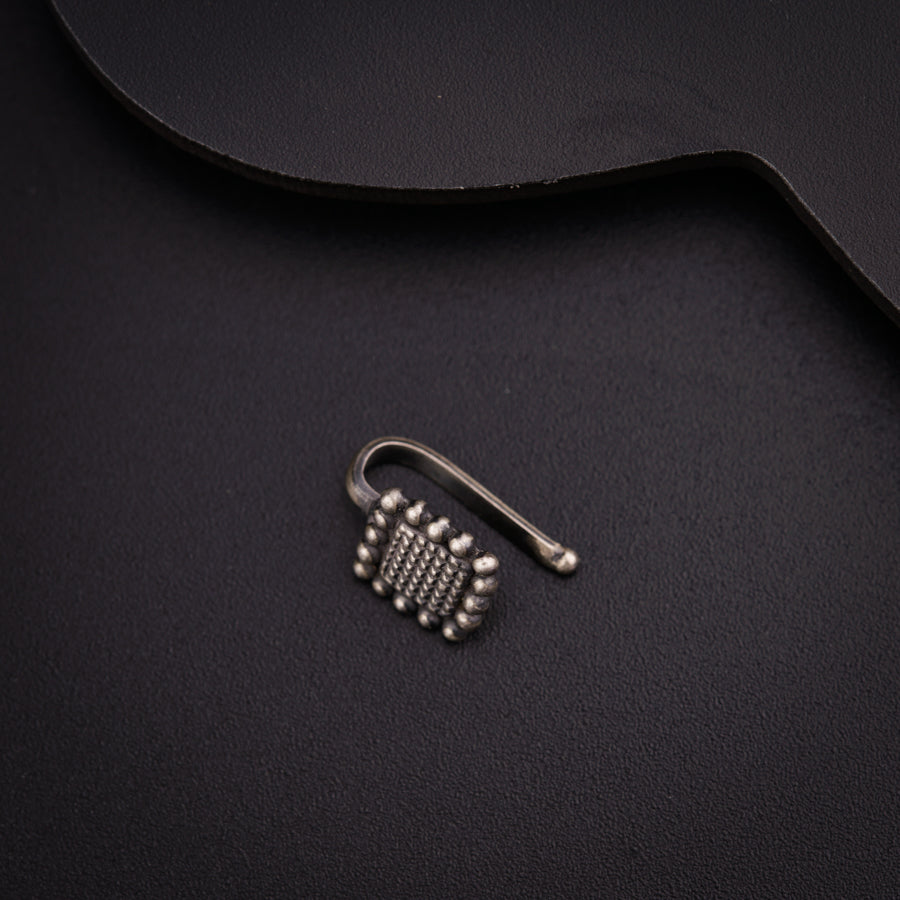 a pair of metal hooks sitting on top of a black surface